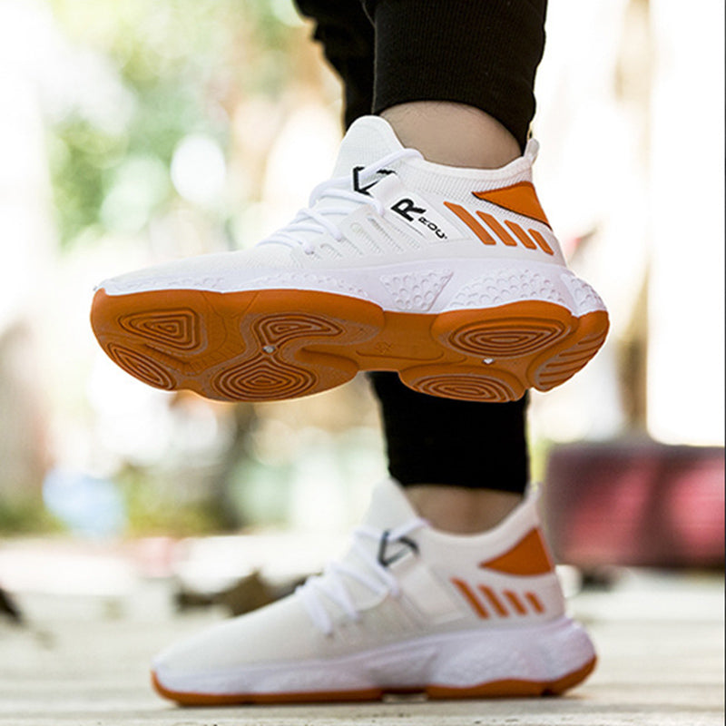 White and orange athletic shoes with a blurred outdoor background