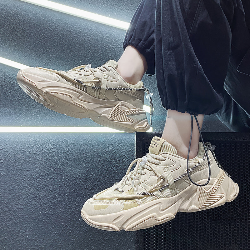 Beige sneakers worn by a person against a dark background