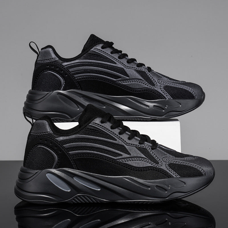 Black sneakers on a reflective surface with a gray background