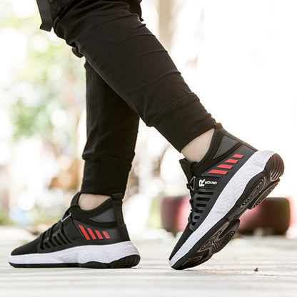 Black and red athletic shoes worn with black pants on a blurred background