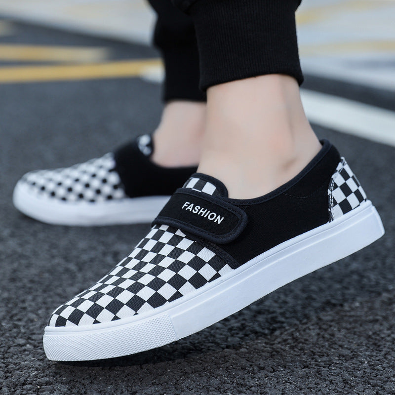 Black and white checkered shoes with a 'Fashion' label on a road surface.
