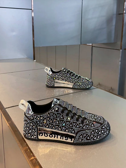 Black and white patterned sneakers with rhinestone embellishments on a reflective surface.