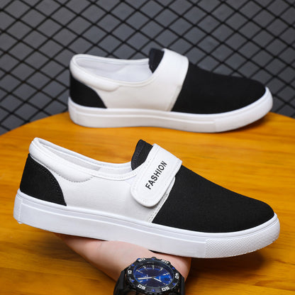 Black and white slip-on shoes with 'Fashion' label on a wooden surface.