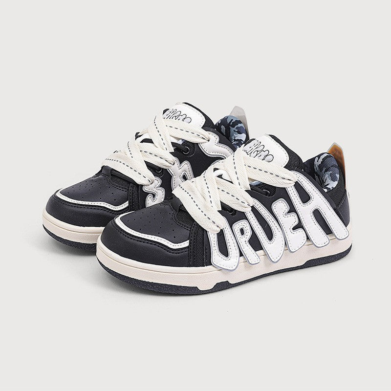 Black and white sneakers with 'UrDeh' branding on a light gray background
