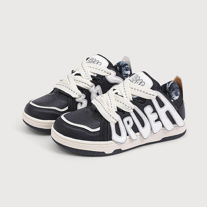 Black and white sneakers with 'UrDeh' branding on a light gray background