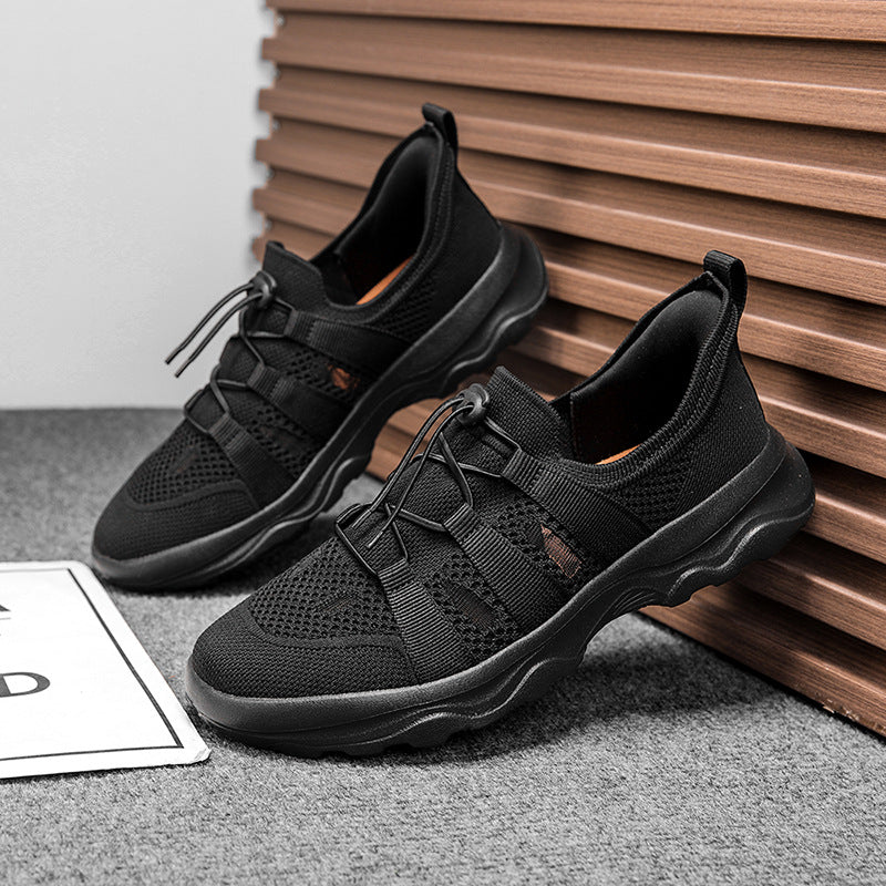Black athletic shoes on a gray surface with a wooden background
