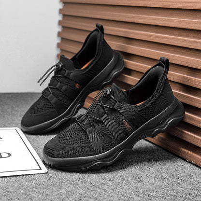 Black athletic shoes on a gray surface with a wooden background