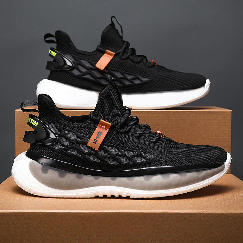 Black athletic shoes with white soles on a brown box against a dark background