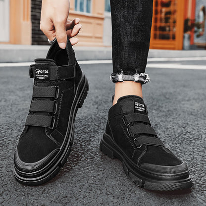 Black high-top sneakers with velcro straps on a street background