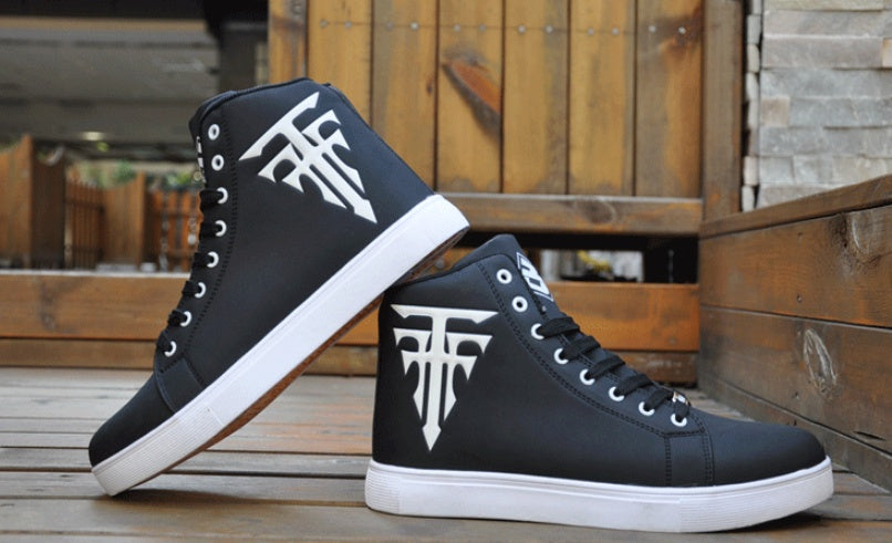 Black high-top sneakers with white logo on a wooden surface