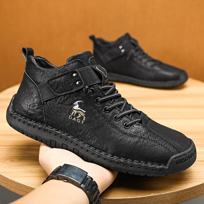 Black leather boots with visible brand logo on a wooden surface