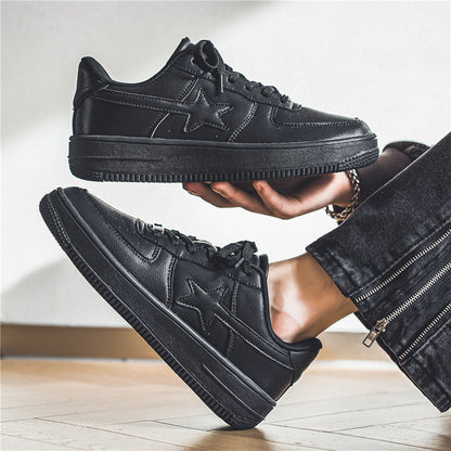 Black sneakers being held up with a neutral background