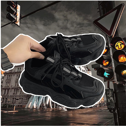 Black sneakers with a hand adjusting the laces, set against an urban background with traffic lights and buildings.