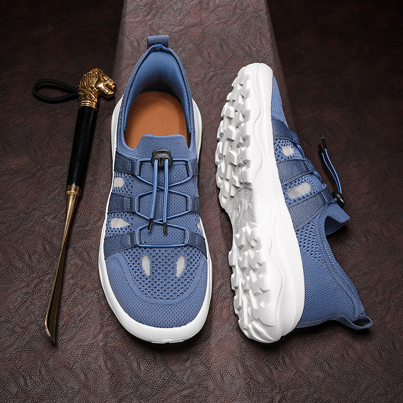 Blue athletic shoes with white soles on a dark textured surface, accompanied by a shoe horn.