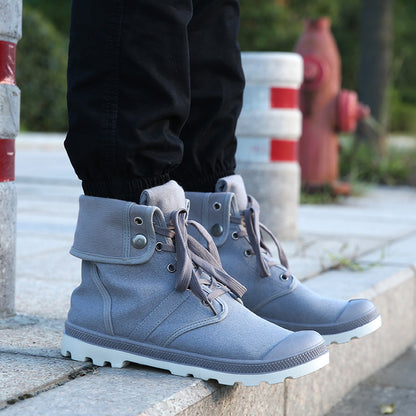 Blue boots worn by a person standing on a sidewalk with a fire hydrant in the background.