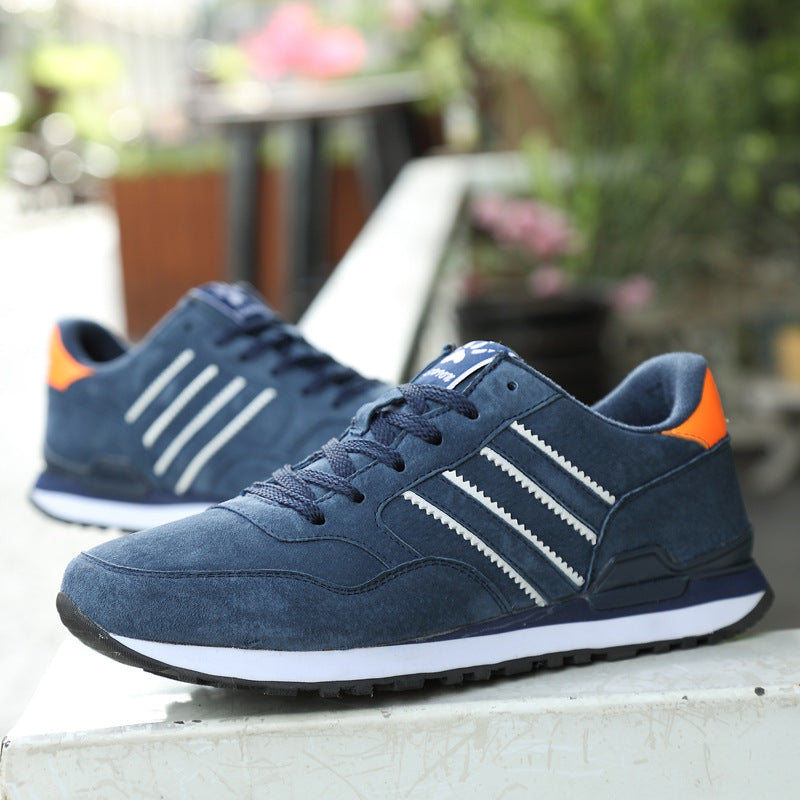 Blue sneakers with orange accents on a blurred outdoor background