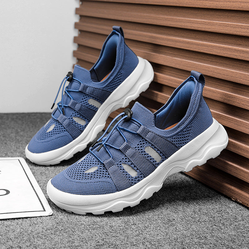 Blue sneakers with white soles on a gray surface with wooden background
