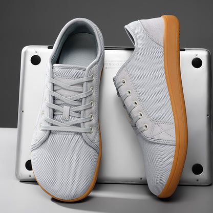 Gray sneakers with brown soles on a metallic surface