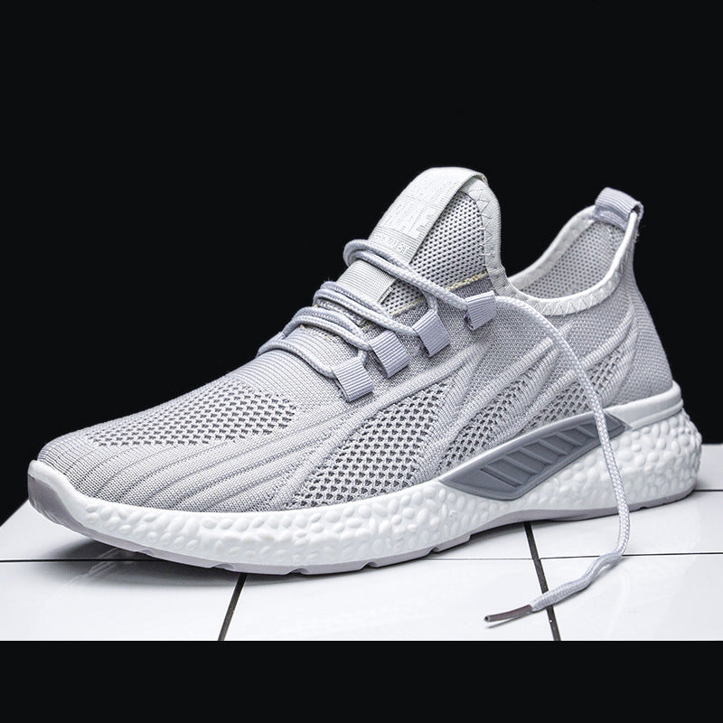 Gray athletic shoe on a white surface with a black background