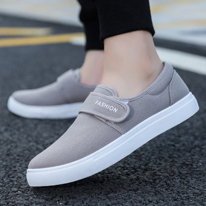 Gray slip-on shoes with white soles on a blurred street background