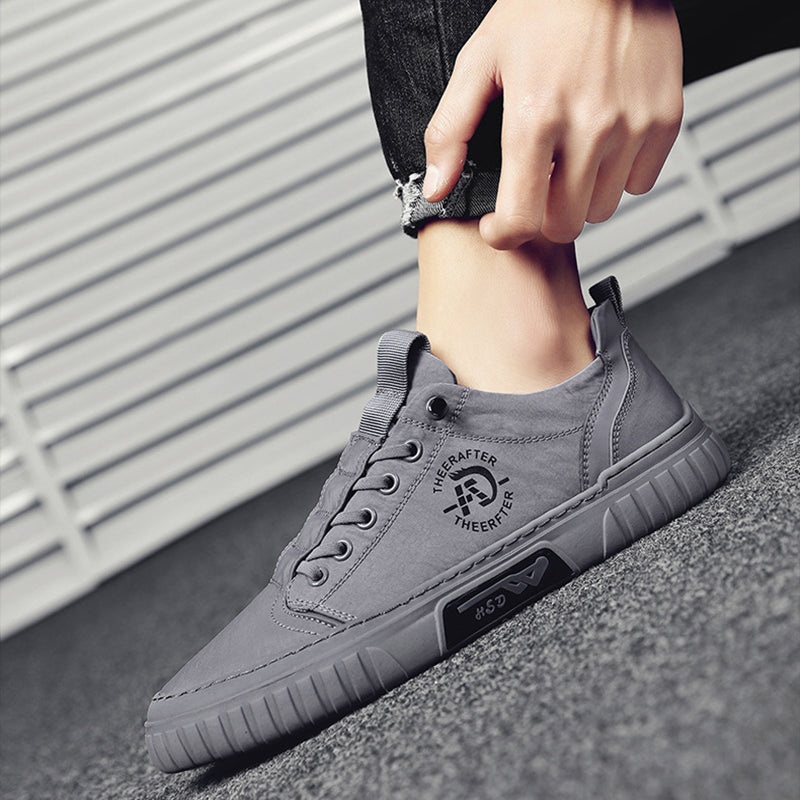 Gray sneakers being worn with a blurred background