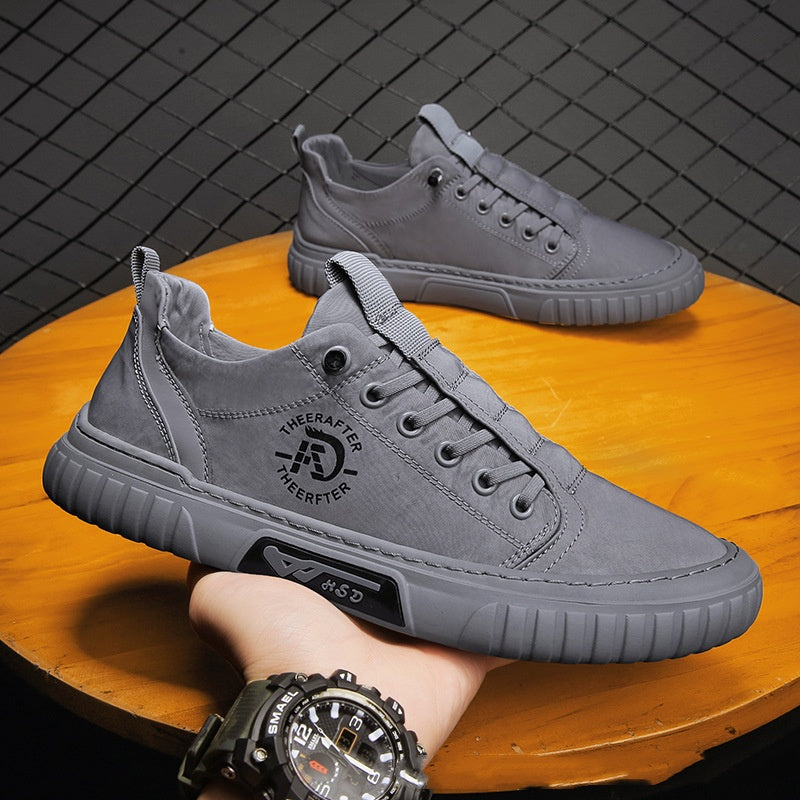 Gray sneakers on a wooden surface with a dark tiled background