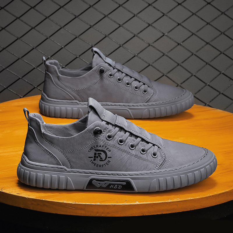 Gray sneakers on a wooden surface with a dark tiled wall background