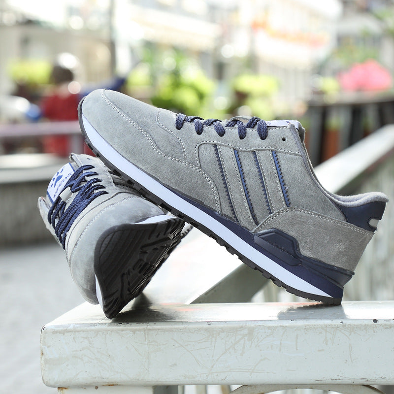 Gray sneakers with blue laces on a metal surface, blurred outdoor background