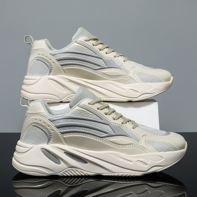 Pair of beige and gray sneakers on a reflective surface with a gray background