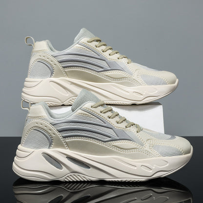 Pair of beige and gray sneakers on a reflective surface with a gray background