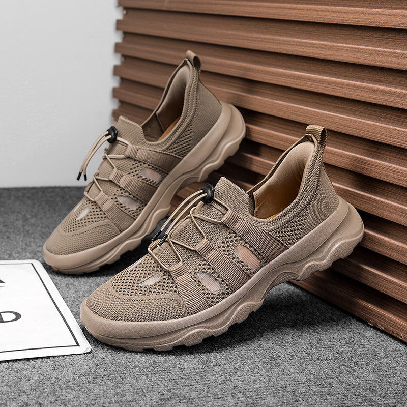 Pair of beige sneakers on a gray surface with a wooden background