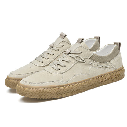 Pair of beige sneakers with white soles on a white background