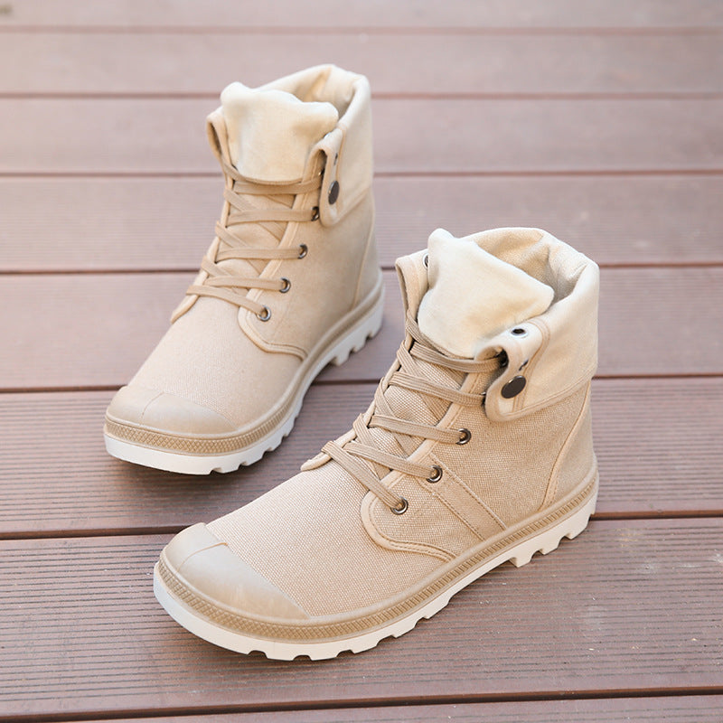 Pair of beige winter boots on a wooden surface