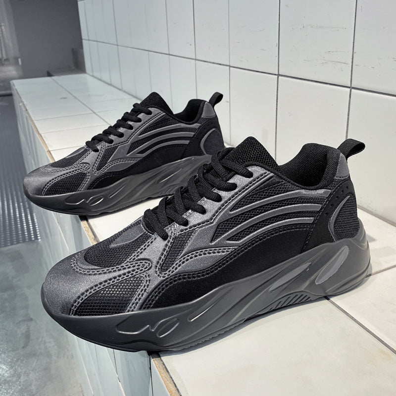 Pair of black and gray sneakers on a white tiled floor.