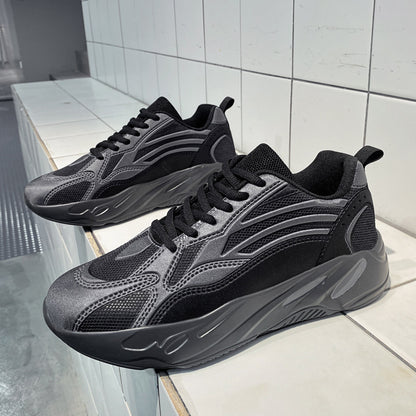 Pair of black and gray sneakers on a white tiled floor.