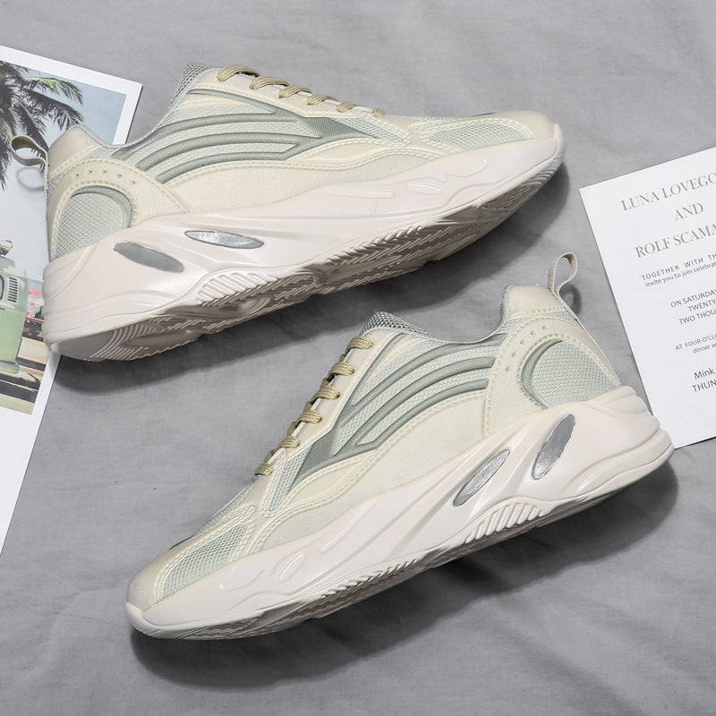 Pair of light-colored sneakers on a gray surface with a magazine underneath.