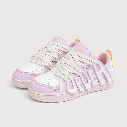 Pair of pink and white sneakers with visible branding on a light gray background