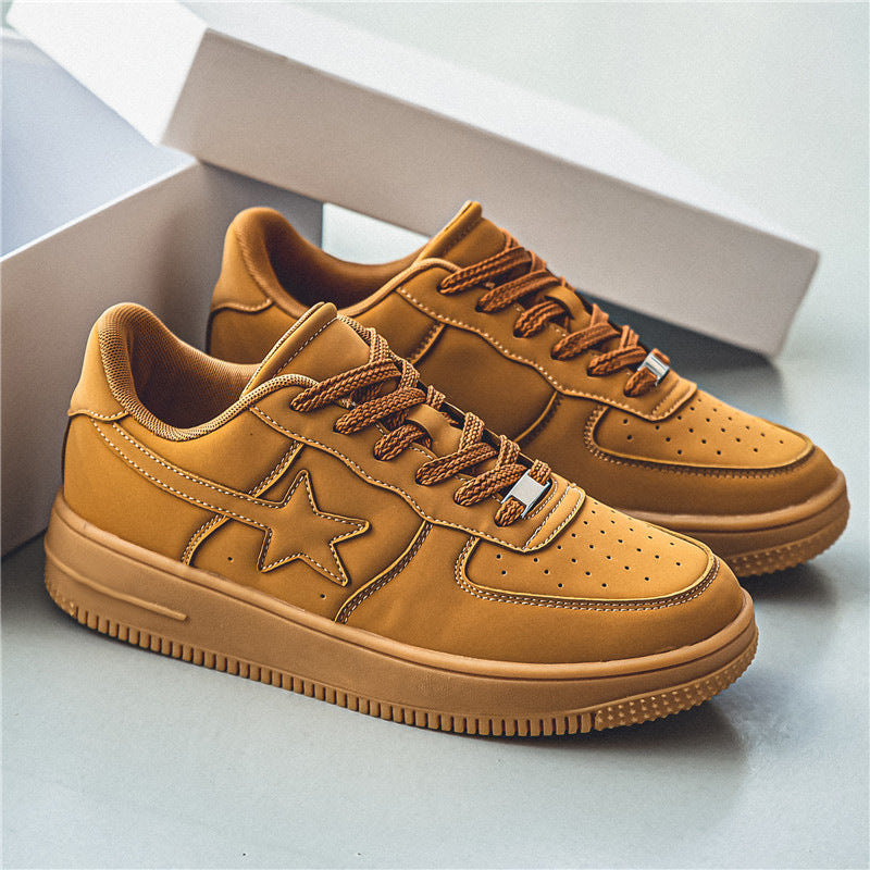 Pair of tan sneakers with a star design on a light background
