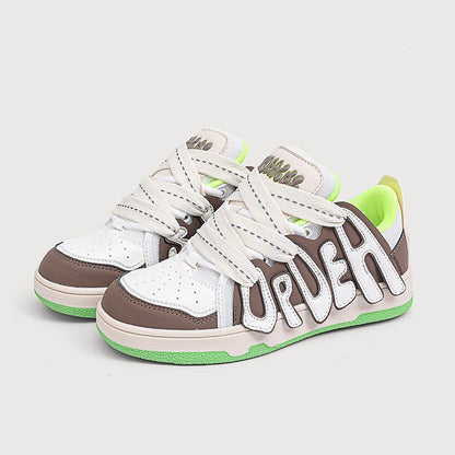 Pair of white and brown sneakers with green accents on a light gray background