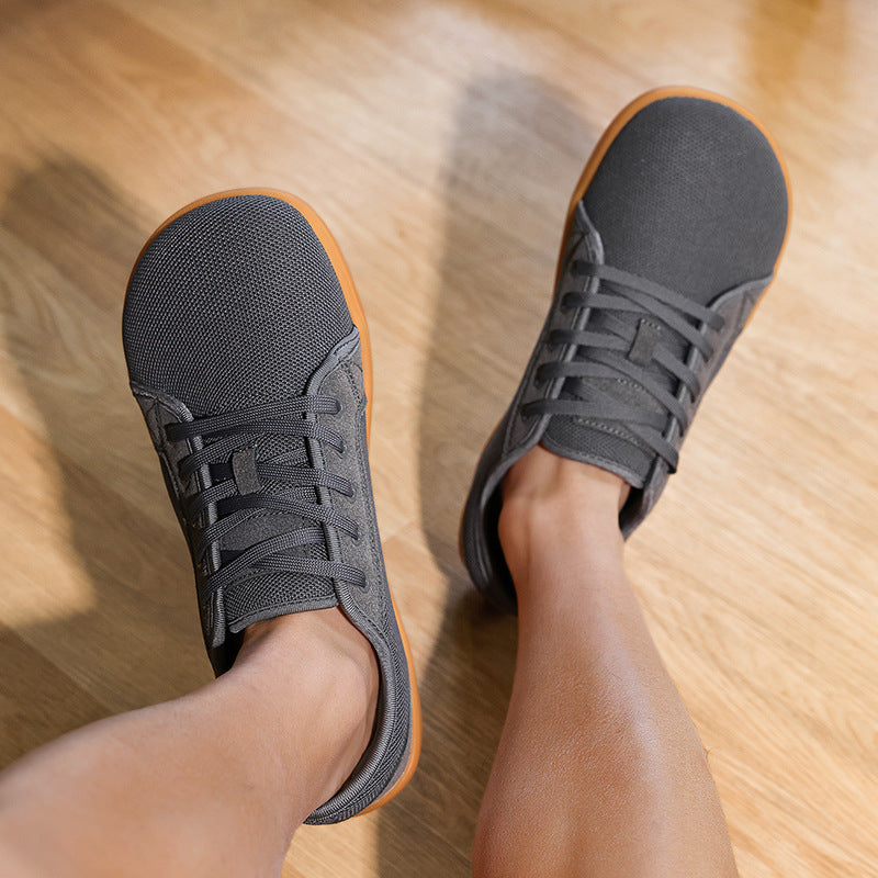 Person wearing black sneakers on a wooden floor