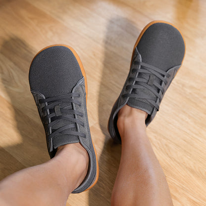 Person wearing black sneakers on a wooden floor