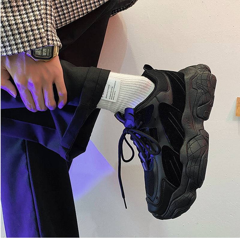 Person wearing black sneakers with a white background