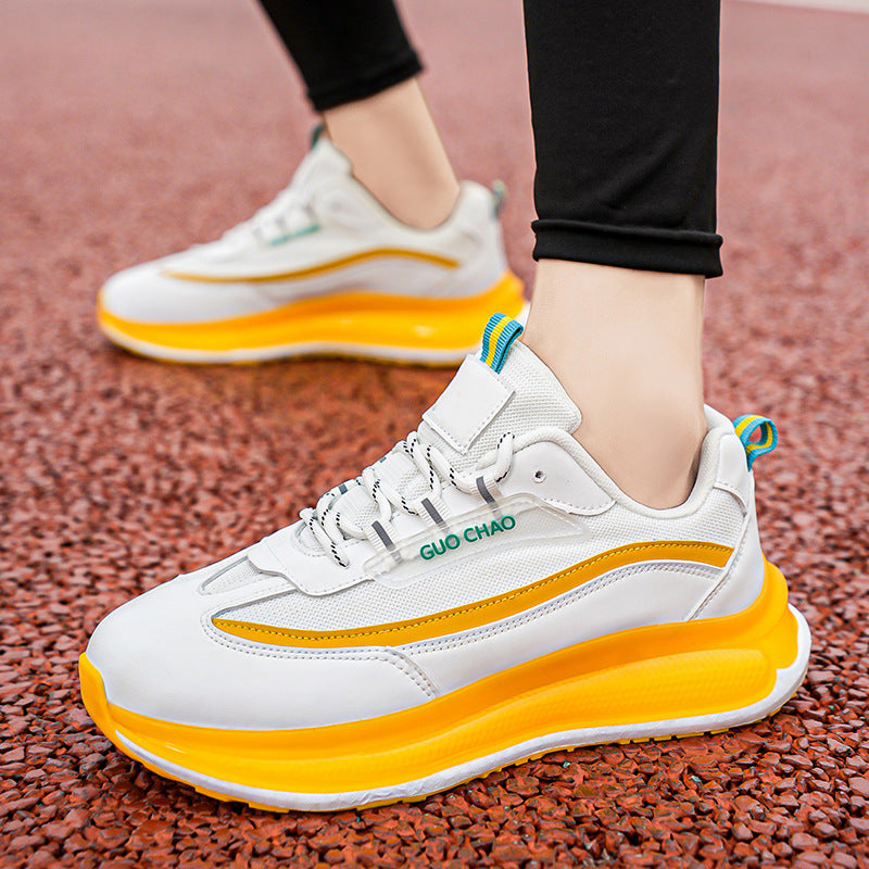 White and orange sneakers with blue accents on a textured surface