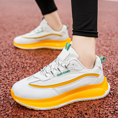 White and orange sneakers with blue accents on a textured surface