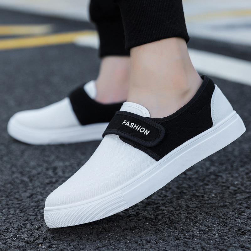 White sneakers with black velcro straps on a road surface