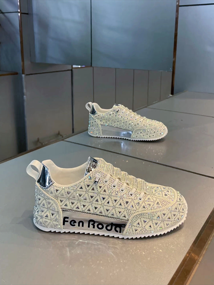 White sneakers with intricate design on a reflective surface