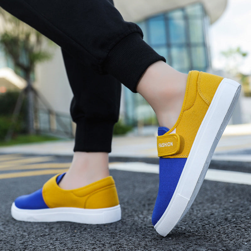Yellow and blue slip-on shoes worn outdoors on a blurred background